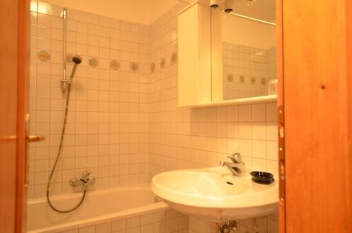 a white bathroom with a sink and a shower at Cá Enrosadira Piano Secondo in San Vito di Cadore