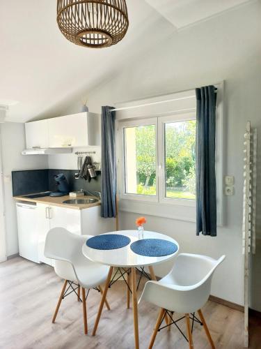 une cuisine avec une table et des chaises dans une pièce dans l'établissement Studio cosy, terrasse privée - Arrivée autonome, à Rouffiac-Tolosan
