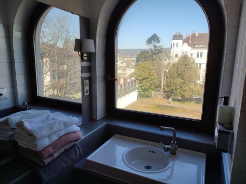 a bathroom with a sink and two windows at Elegant, Suite, Swimming Pool in Wiesbaden