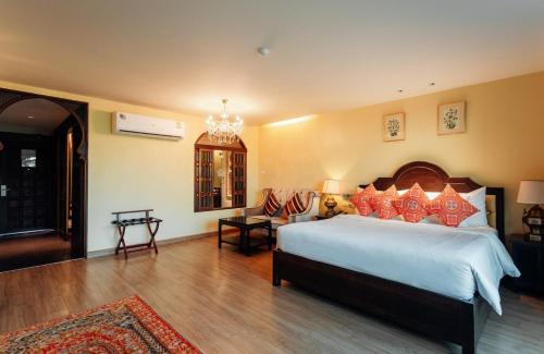 a bedroom with a large bed and a chandelier at SHEIK ISTANA HOTEL CHIANGMAl in Chiang Mai