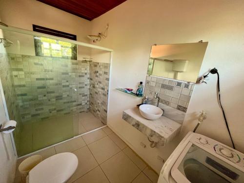 a bathroom with a shower and a sink and a mirror at BOIPEBA Villa 4 quartos in Ilha de Boipeba