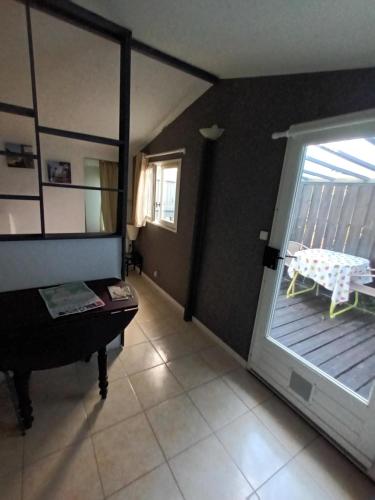 un salon avec un piano et une porte donnant sur un balcon dans l'établissement Cabane d Andernos les bains, à Andernos-les-Bains