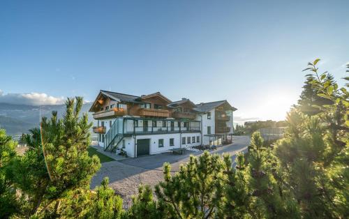 a house on a hill with trees in the foreground at Hotel Winterer in Schladming