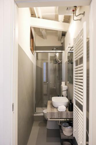a bathroom with a sink and a toilet and a shower at Moss & Stone - 3 min walk to piazza Vittoria in Brescia