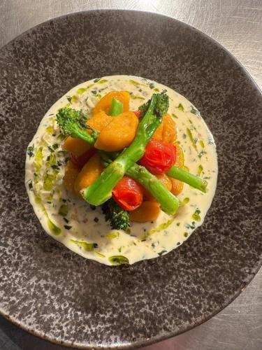 a plate of food with vegetables on a table at Santo's Higham Farm Hotel in Alfreton