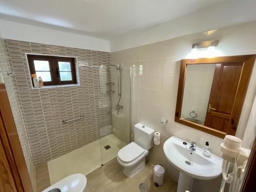 Un baño con inodoro, lavabo y ducha. en Las Brisas Villa 106, en Playa Blanca