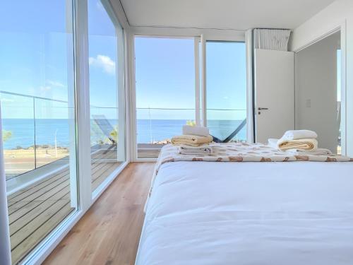 a bedroom with a large bed with a view of the ocean at Pedra do Mar in São Roque