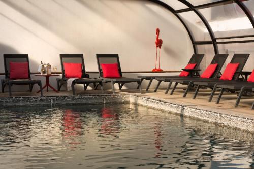 a pool with chairs and a table and water at Vila De La Mar & Spa in Saintes-Maries-de-la-Mer
