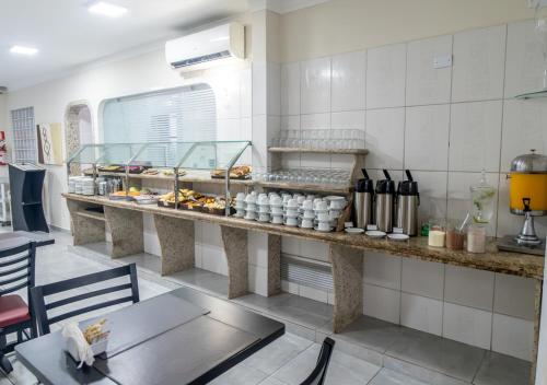 a restaurant with a counter with a lot of food at Hotel Nacional Inn Guarujá in Guarujá