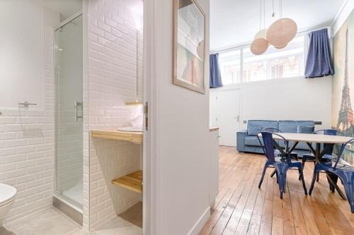 La salle de bains est pourvue d'une douche et d'une table avec des chaises. dans l'établissement MyKeypers - Modern & Cozy Duplex 6P - Arc de Triomphe, à Paris