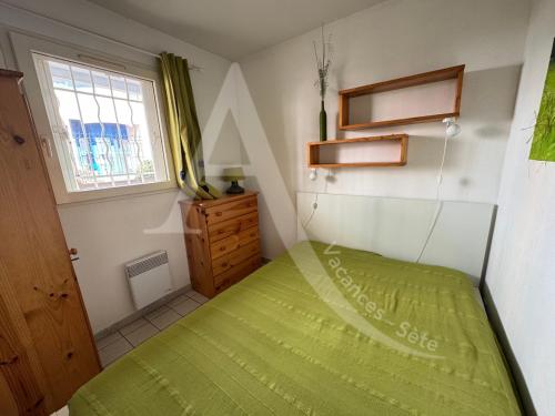 - une petite chambre avec un lit vert et une fenêtre dans l'établissement 1 CHAMBRES, PKG, A MI CHEMIN ENTRE PLAGES ET CENTRE HISTORIQUE, à Sète