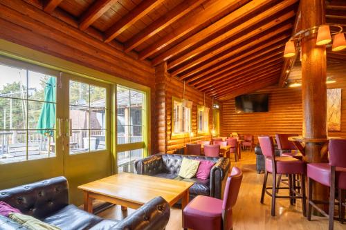 a restaurant with a couch and tables and chairs at Coylumbridge Resort Hotel in Aviemore