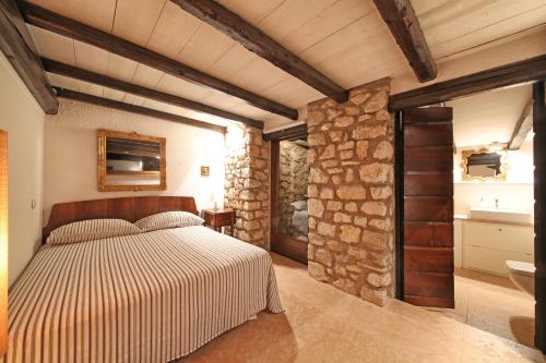 トスコラーノ・マデルノにあるVilla dei Rosmariniの石壁のベッドルーム1室(ベッド1台付)