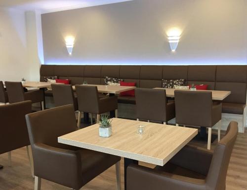 a dining room with tables and chairs and lights at Hotel Am Quellberg in Recklinghausen