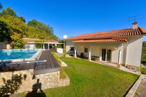 a backyard with a pool and a house at Casa Bianca in Caldas da Rainha