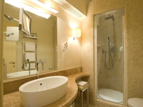 a bathroom with a large white sink and a shower at Roccamare Resort - Casa di Ponente in Castiglione della Pescaia