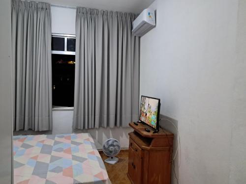 a bedroom with a bed and a television on a dresser at Apartamento estilo flat em Copacabana in Rio de Janeiro