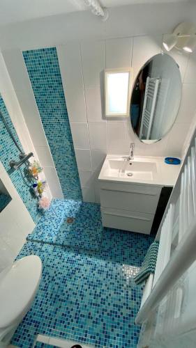 une salle de bain avec un lavabo et un miroir dans l'établissement La maison aux volets bleus, à Bandol