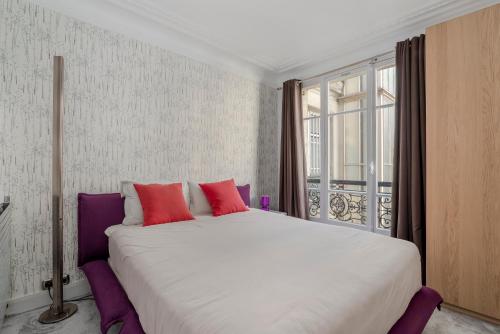 un grand lit dans une chambre avec une grande fenêtre dans l'établissement 4 Bedroom Avenue Kléber, à Paris