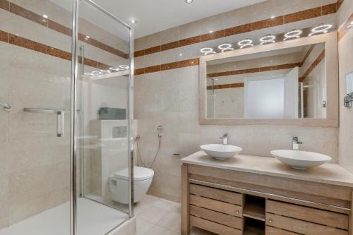 une salle de bain avec deux lavabos et une douche dans l'établissement 4 Bedroom Avenue Kléber, à Paris