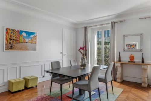 une salle à manger avec une table et des chaises dans l'établissement 4 Bedroom Avenue Kléber, à Paris