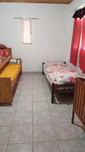 a room with two beds and a tiled floor at Marcelo Buja in Jardín América