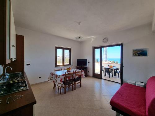 una cucina e un soggiorno con tavolo e sedie di Villa Eugenia a Tropea