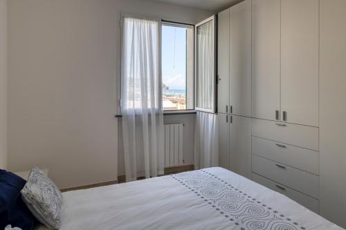 a bedroom with a bed and a large window at Aurora d'Elysium in Spotorno