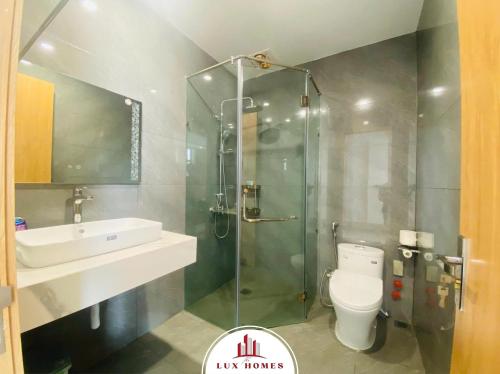 a bathroom with a shower and a toilet and a sink at The LuxHomes Apartment ᵀᴹ I HOT Độc Đáo Nhất Vinhomes Marina in Hai Phong