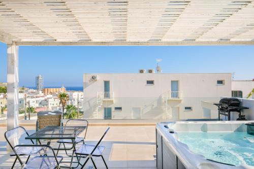 a balcony with a table and chairs and a hot tub at Le Cammire Luxury Apartment - Leuca in Leuca