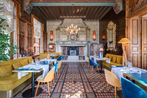 a restaurant with tables and chairs and a fireplace at Château des Avenieres in Cruseilles