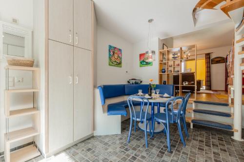 a living room with a table and blue chairs at Strandtraum Lobbe Fewo 20 bis 4 Personen, auf Anfrage mit Strandkorb in Lobbe