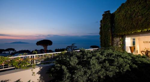 a building with a view of the ocean at night at Jumeirah Capri Palace in Anacapri