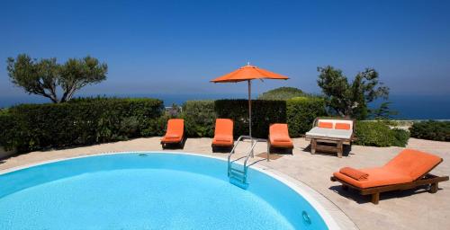 a swimming pool with lounge chairs and an umbrella at Jumeirah Capri Palace in Anacapri