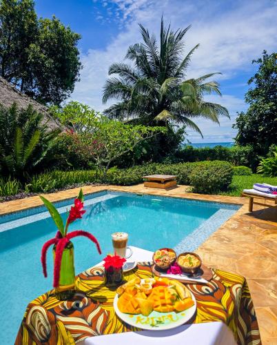 un tavolo con del cibo sopra accanto a una piscina di Zanzi Resort Private Paradise a Zanzibar City