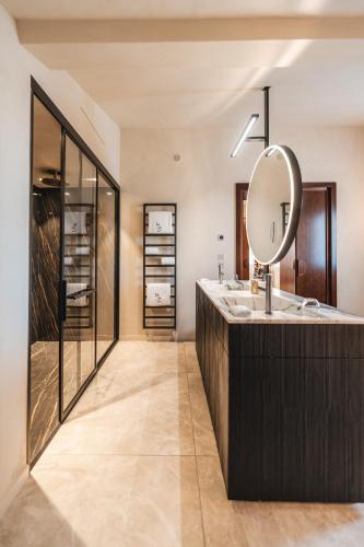 une salle de bain avec un lavabo et un miroir dans l'établissement Hôtel de Pavie, à Saint-Émilion