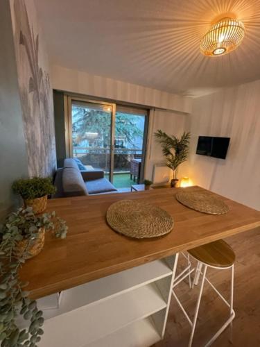 - un salon avec une table en bois et 2 chaises dans l'établissement Studio carré d’or Juan les Pins, à Antibes