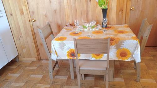 a dining room table with a table cloth with sunflowers on it at Cabaña San Isidro in Coipue