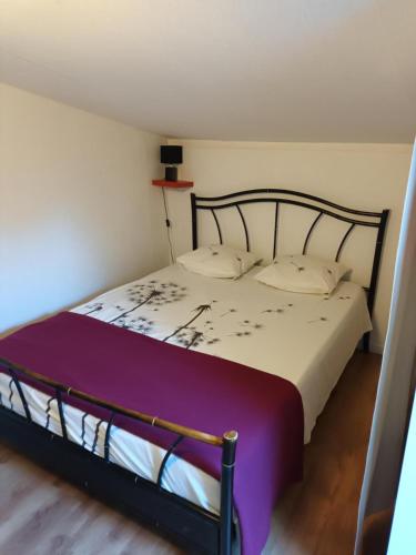 - une chambre dotée d'un lit avec des draps violets et blancs dans l'établissement Cabane d Andernos les bains, à Andernos-les-Bains