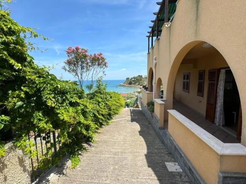 an empty street next to a building with a view of the ocean at Casa Archi in Cefalù