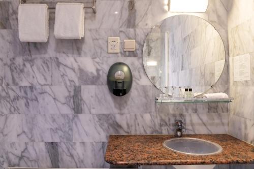 a bathroom with a sink and a mirror at Hotel Rooms in Breskens