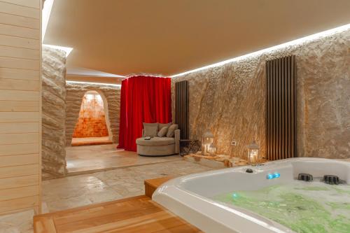 un bagno con vasca e un divano in camera di Villa Piscina La Trinità a Corciano