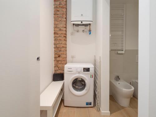 a small bathroom with a washing machine and a sink at Luxury apartment - Flumendosa 5 in Milan