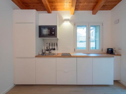 a kitchen with white cabinets and a window at Luxury apartment - Flumendosa 5 in Milan