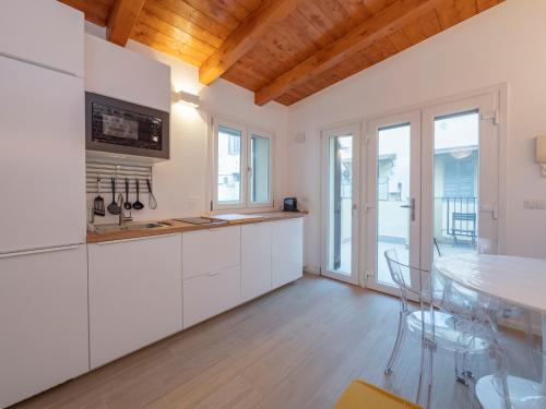 a kitchen with white cabinets and a table with chairs at Luxury apartment - Flumendosa 5 in Milan