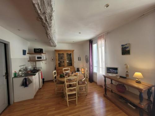 un salon avec une table et une cuisine avec une table dans l'établissement Grand studio chez Lucie, à Cotignac