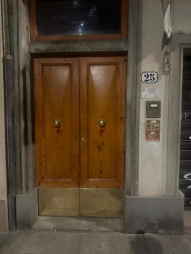 two wooden doors on the side of a building at Florence F&M Via Maggio in Florence