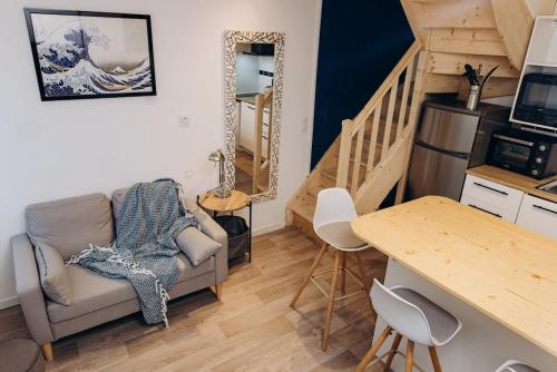 un salon avec un canapé et un escalier dans l'établissement Le grand bleu, à Étretat