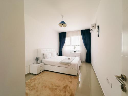 Un dormitorio blanco con una cama y una ventana. en Caesar Resort 2 Bedroom, Pool View, Close to the Beach, en Trikomo
