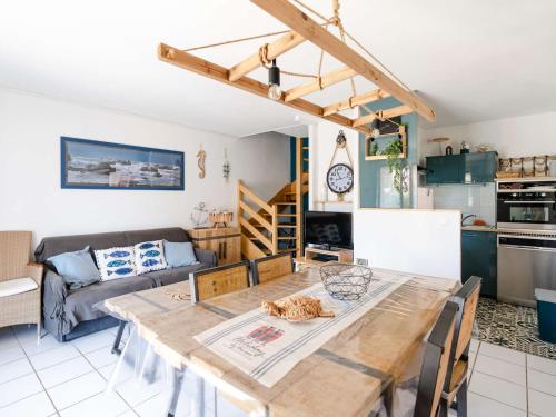 Il comprend une cuisine et un salon avec une table en bois. dans l'établissement Pavillon T3 rénové, proche plage, 2 chambres, terrasse, garage, WiFi - FR-1-409-170, à Narbonne